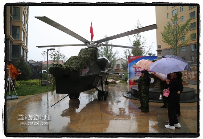 小區(qū)突然出現(xiàn)“飛機(jī)坦克”，其中殲15艦載戰(zhàn)斗機(jī)一架、99式主戰(zhàn)坦克一輛、武直-10武裝直升機(jī)一架，吸引了眾多市民雨中圍觀、合影。